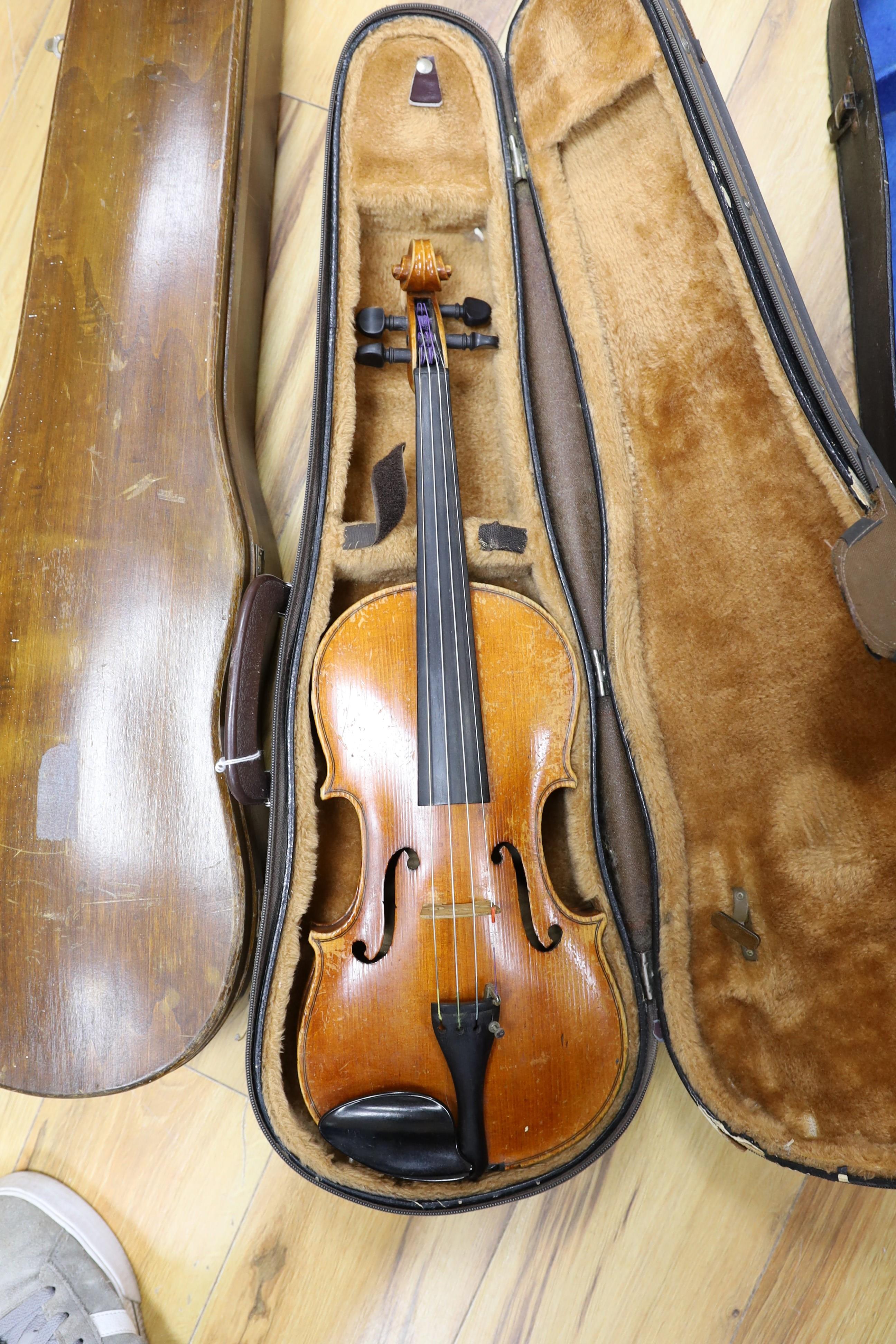 Two cased three quarter size violins, one labelled the London violin co Ltd, length of back 33.5 cm together with a wooden violin case